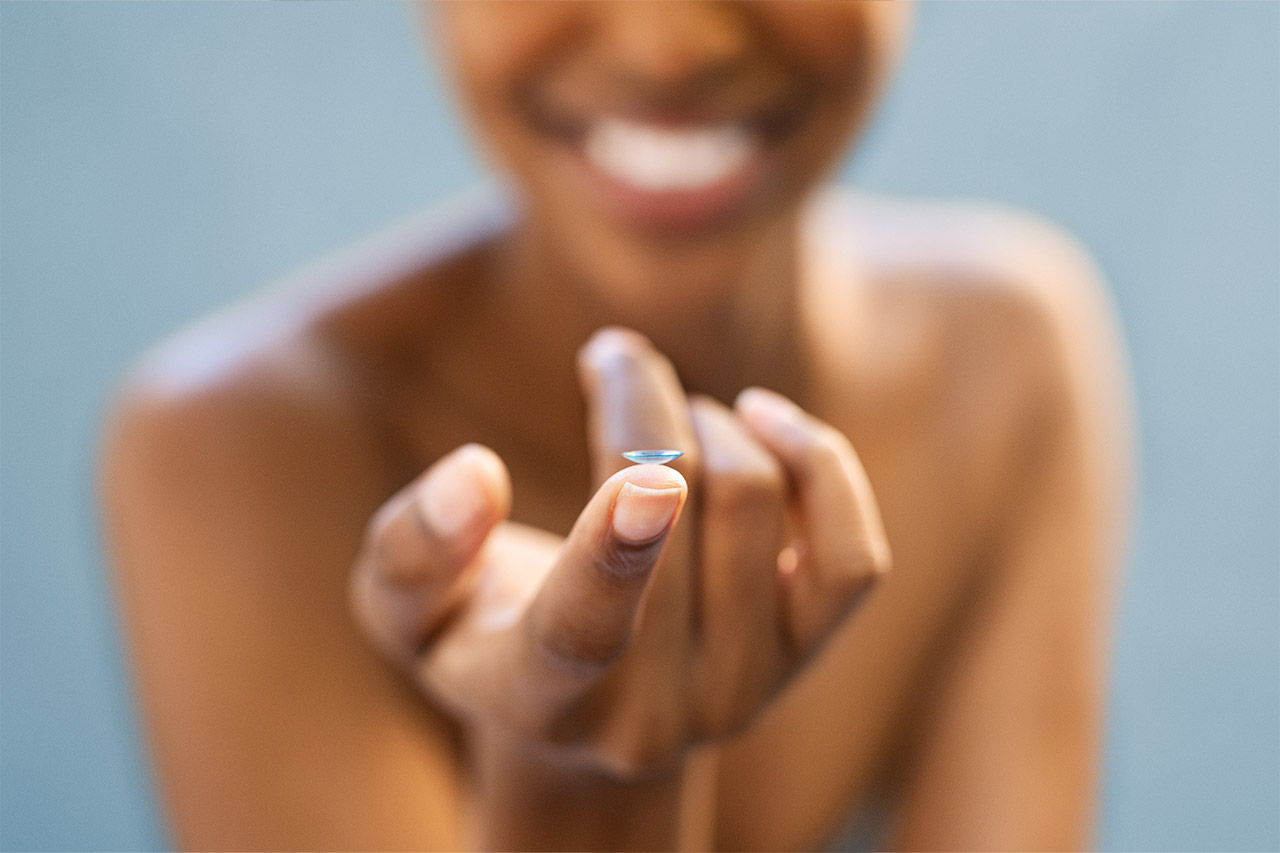 1280 close up of contact lens on womans finger